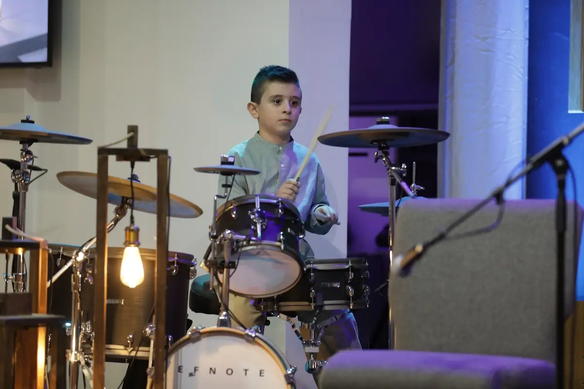 Young student playing drums on stage